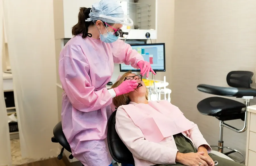A hygienist at Davis & Engert Dentistry cleaning a patient's teeth.