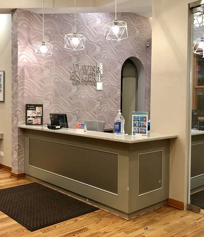 The reception at Davis & Engert Dentistry, with its patterned feature wall and pendant lights.